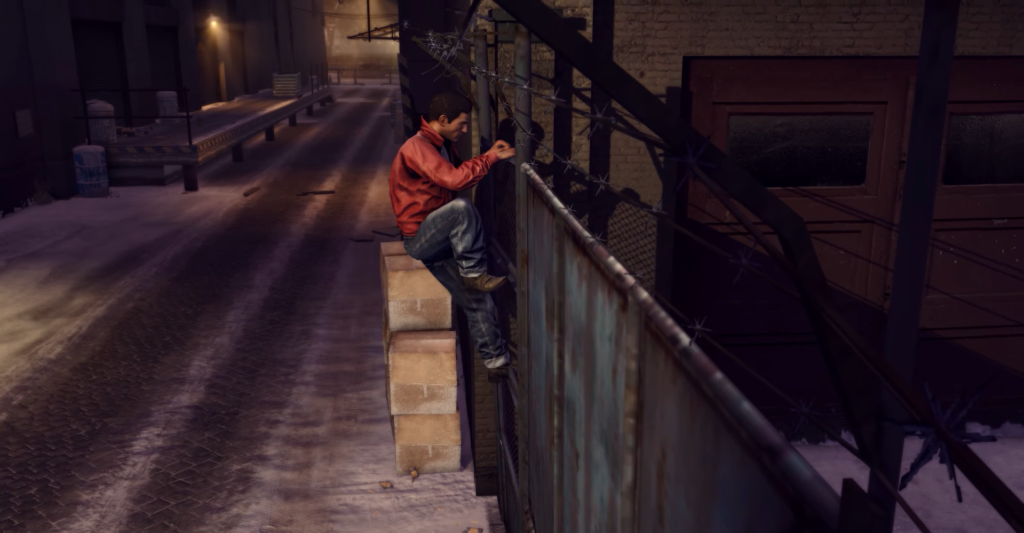 Man climbing barbed-wire fence at night.