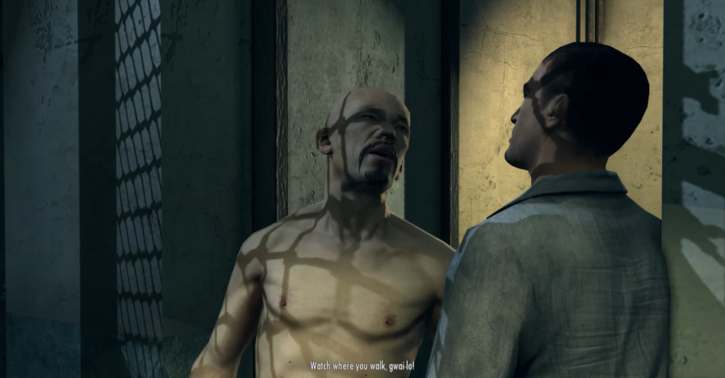 Shirtless man confronts suited man indoors.