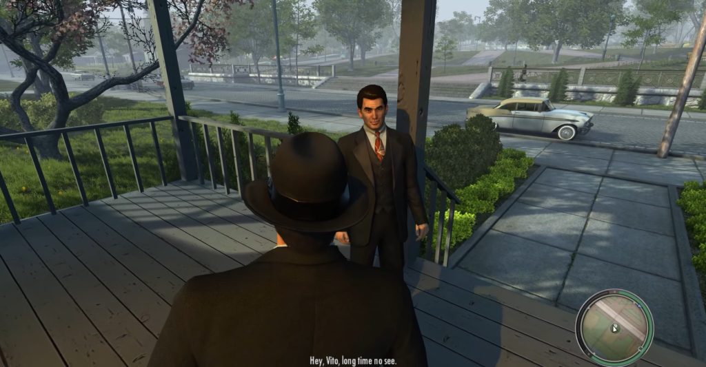 Man in suit greets another man.