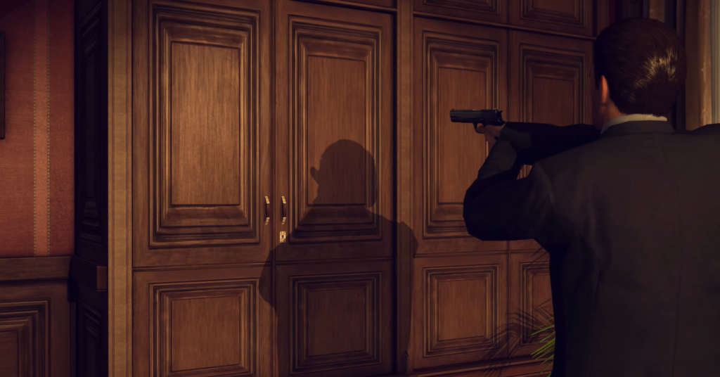 man aiming gun at wooden cabinet