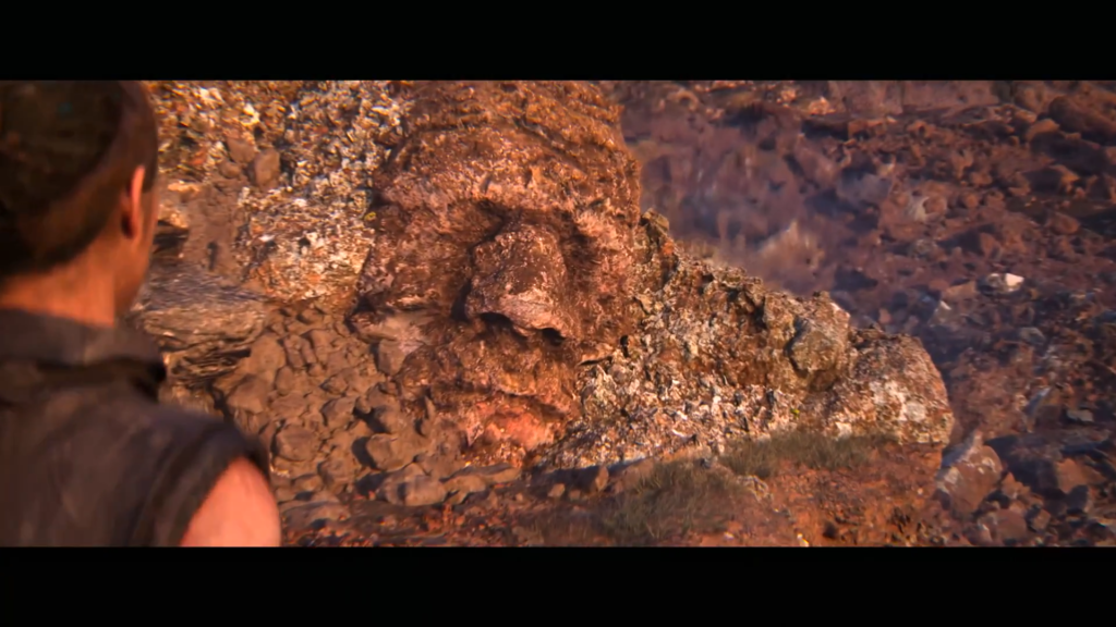 Woman looks at giant stone face in canyon