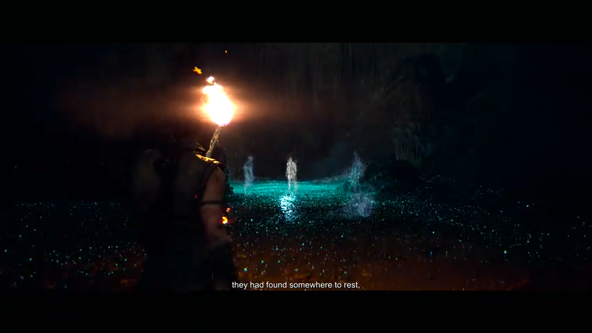 Person holding torch facing glowing pool in cave