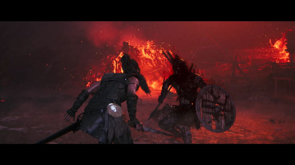 Senua fights armored warrior amid burning village in Hellblade