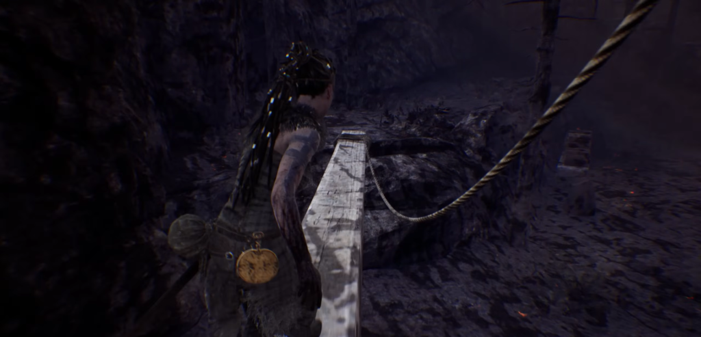 Senua walking on wooden plank bridge in Hellblade