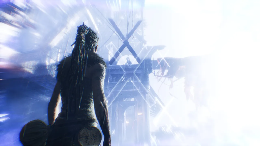 Senua walks toward towering structure in bright mist