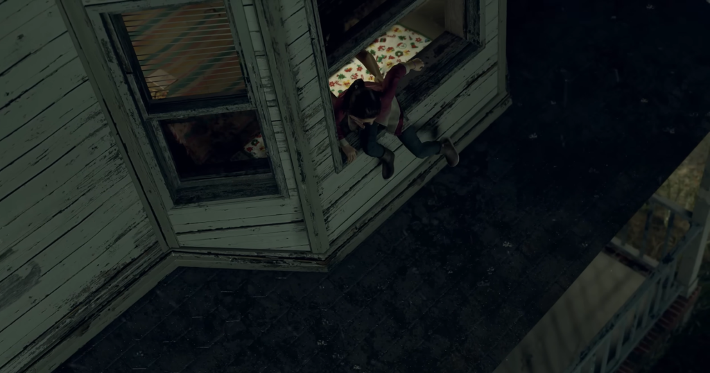 Person climbing out window onto rooftop at night