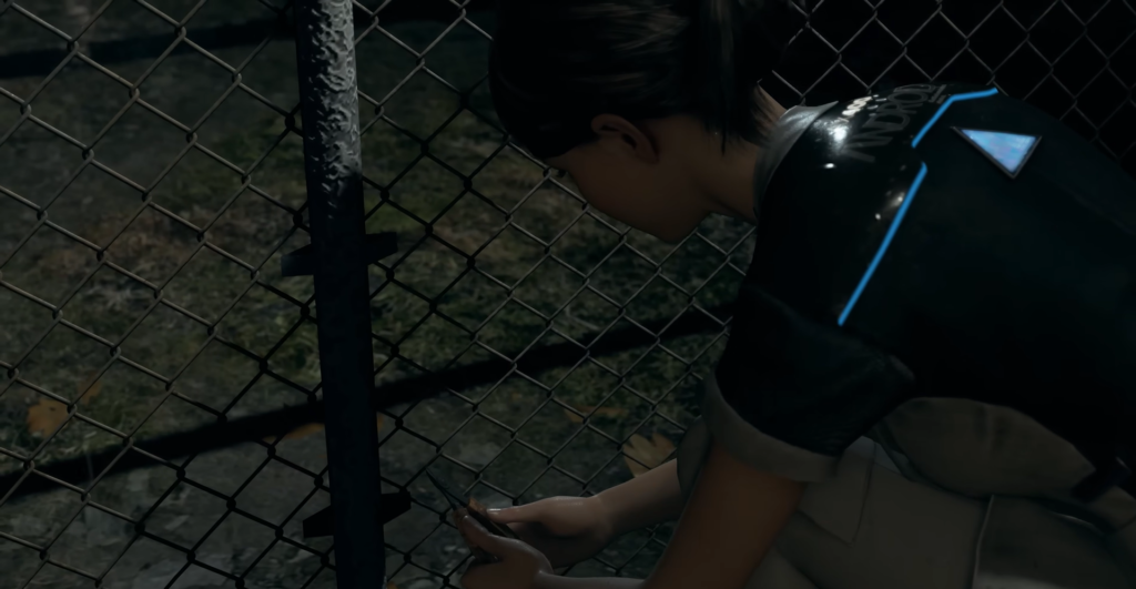 Kara from Detroit: Become Human crouches by chain-link fence