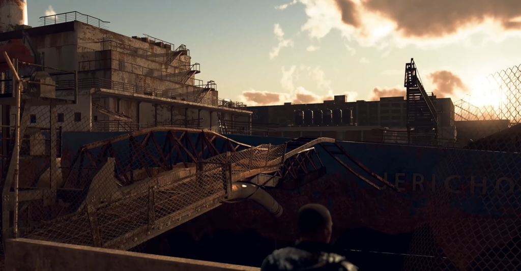 Person looking at collapsed bridge in industrial yard at sunset