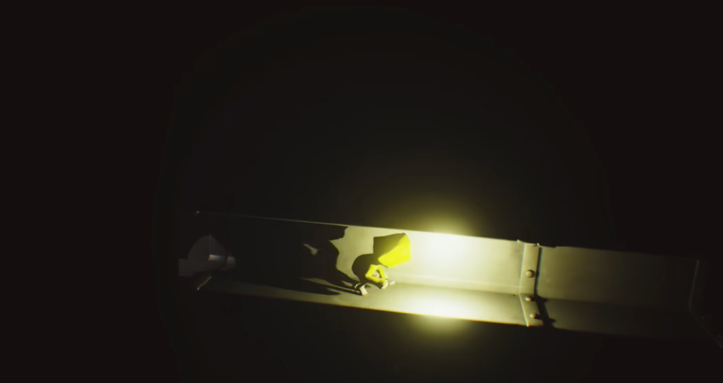Yellow figure crawling along lit metal beam in darkness
