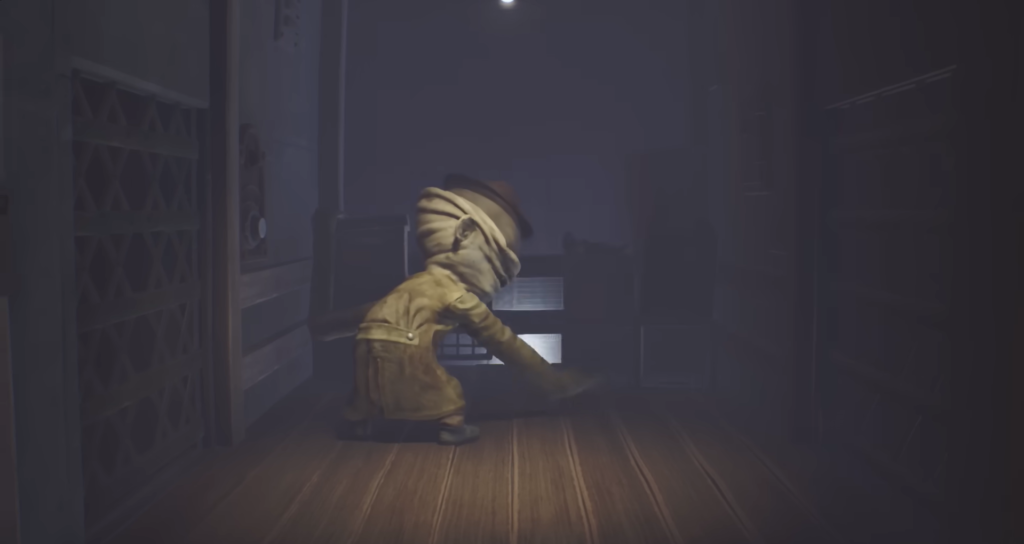 Mono dragging an axe in Little Nightmares hallway