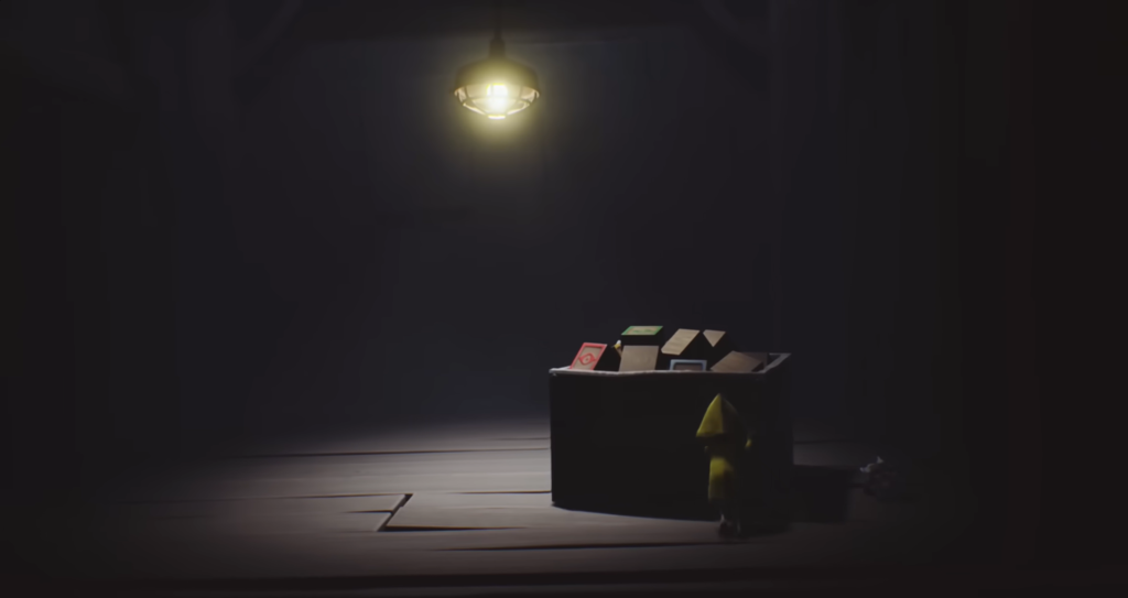 Six from Little Nightmares stands beside box under lamp