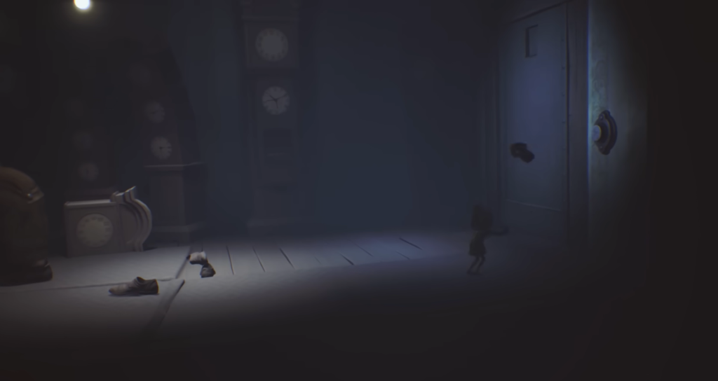 Small figure runs toward door in dark room