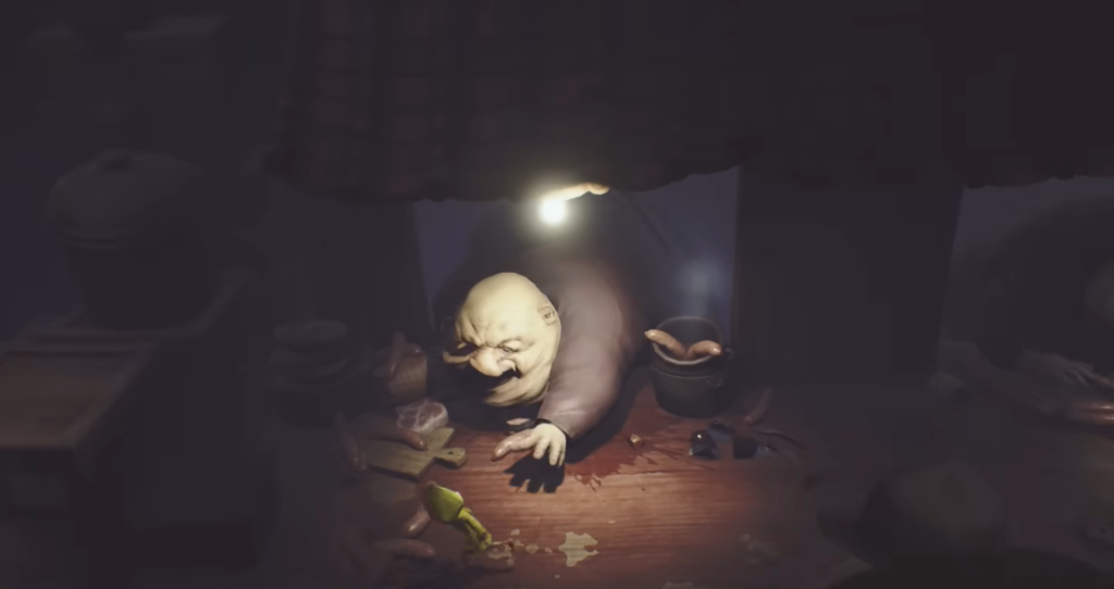 Bald man crawls through table opening in dark room