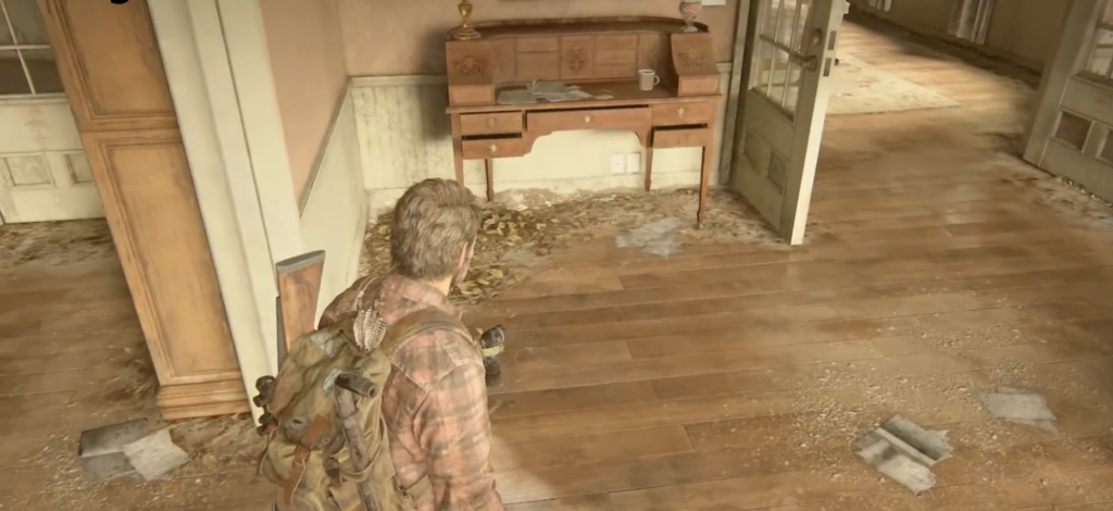 Joel explores abandoned house hallway in The Last of Us