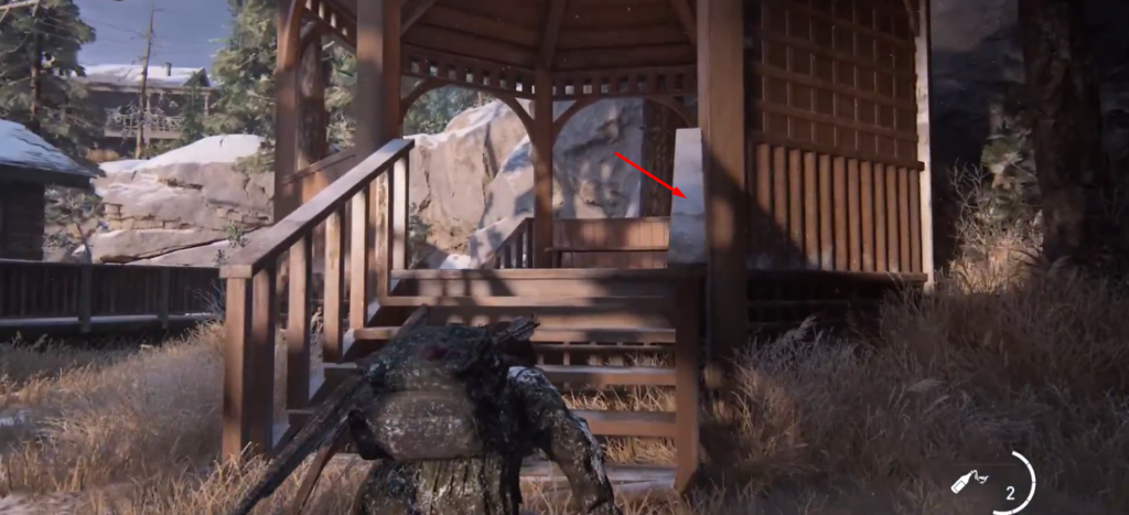 The Last of Us Part II character crouching near gazebo stairs