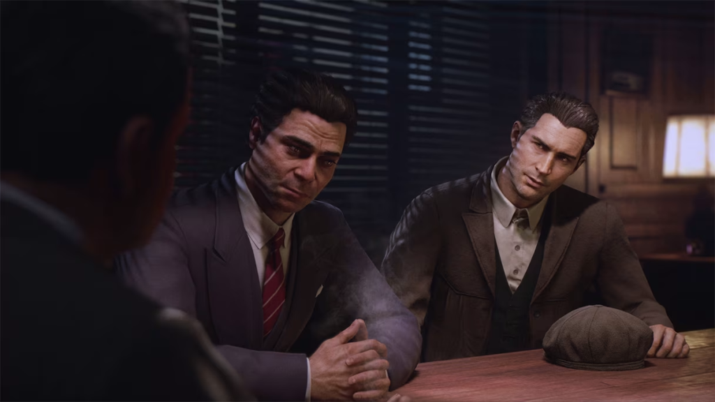 Two men in suits sit at table indoors