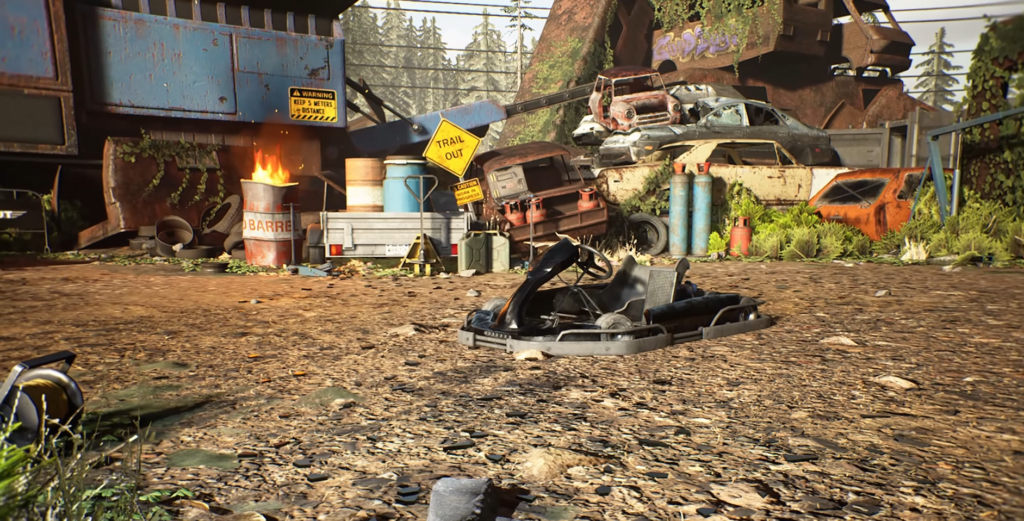Burning barrel beside junkyard cars and debris outdoors