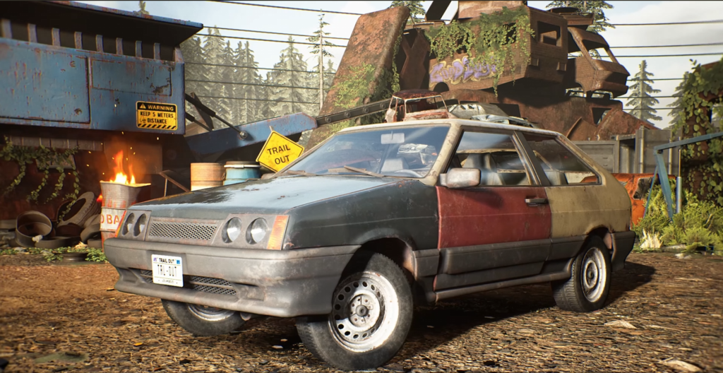 Rusty hatchback parked in scrapyard with burning barrel