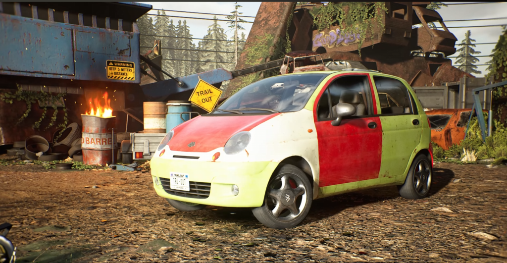 Red and green compact car parked in scrapyard