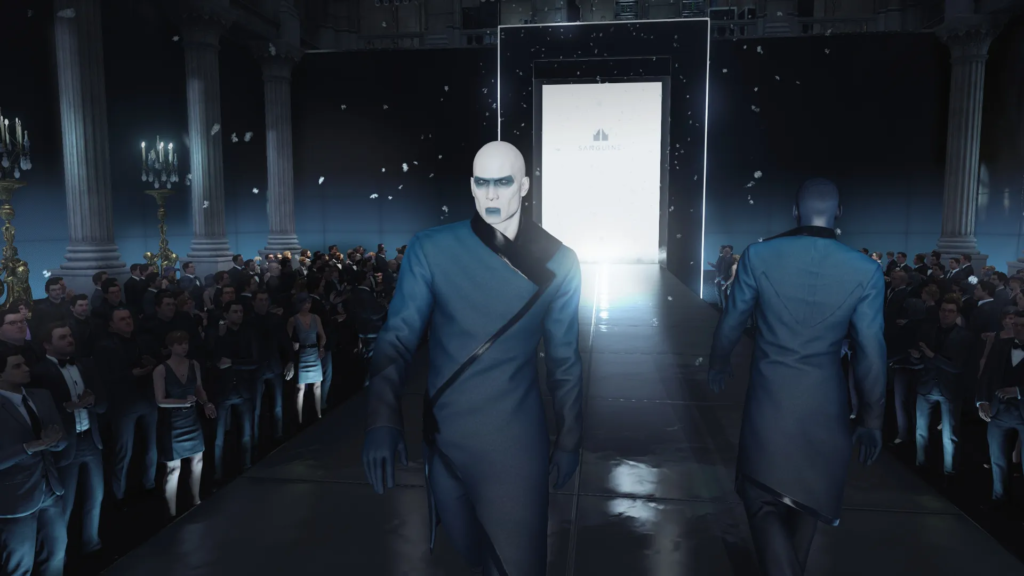 Bald man walking runway past crowd in hall