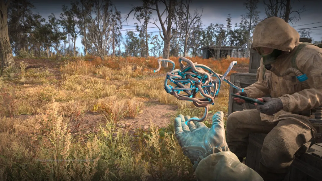 Gloved hand holding blue artifact near seated soldier outdoors