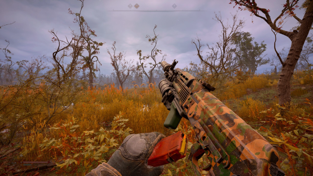 Camouflage rifle held in autumn forest