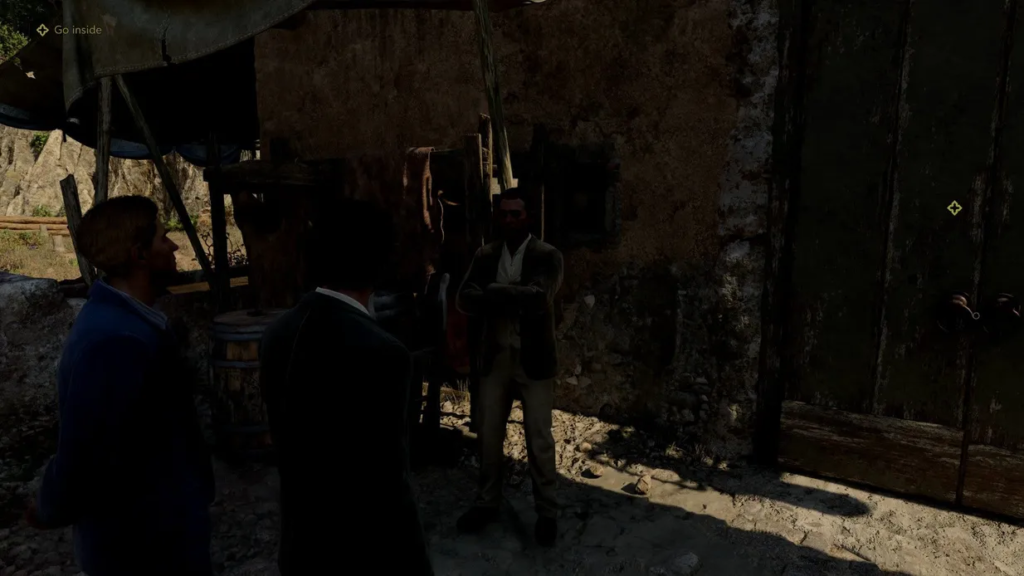 Two men talking to man outside rustic building