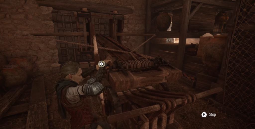 Amicia de Rune turns winch in barn workshop