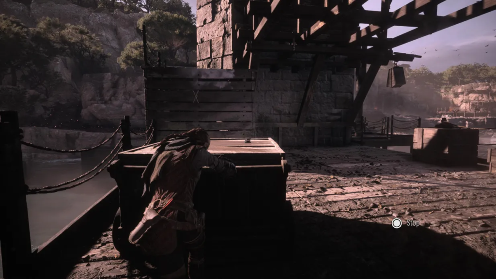 Lara Croft hiding behind crate in ruins.
