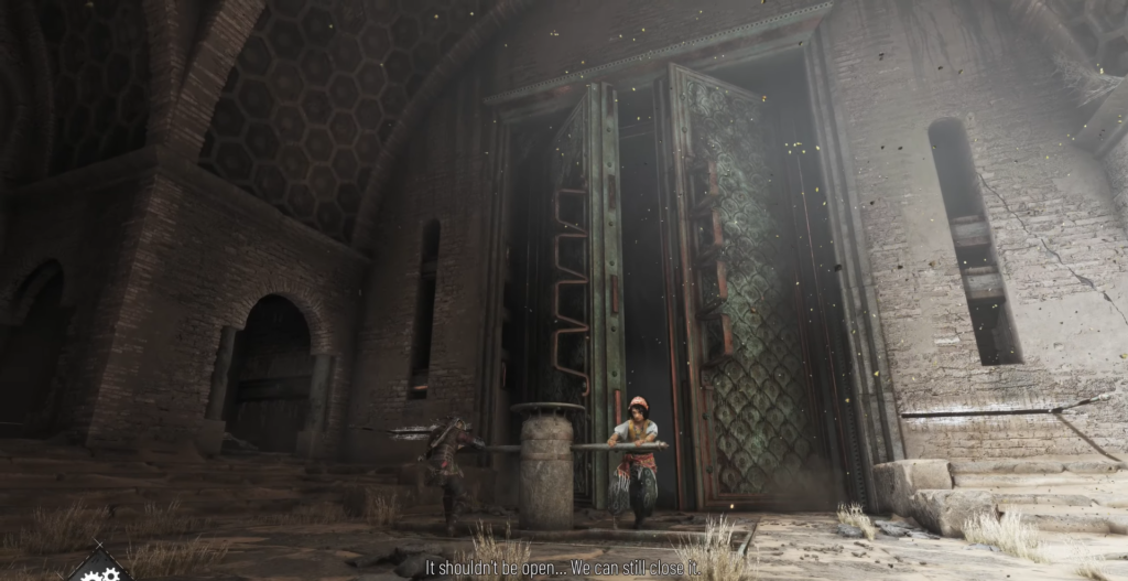 Man standing near large doors in dusty setting.