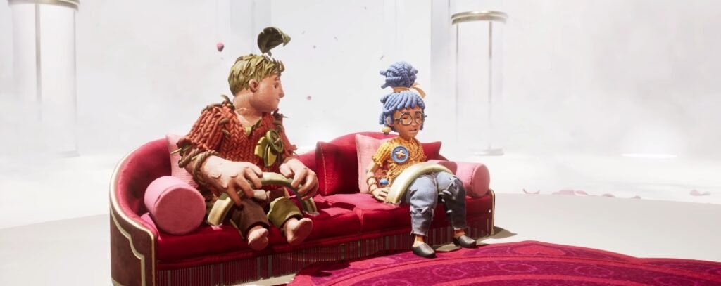 Cody and May from It Takes Two sitting on red sofa